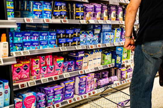 Shopper With A Basket Browsing Aduld Incontinence And Feminine Hygiene Prodicts In A UK Supermarket