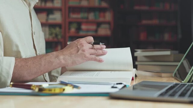 Researcher conducts research across open textbook pages, continuing careful research alongside academic study tools where methodical study aids learning.