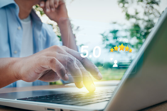 Man typing on laptop with digital five-star rating and customer review interface in outdoor nature setting, concept of customer satisfaction, service quality feedback, and online evaluation.