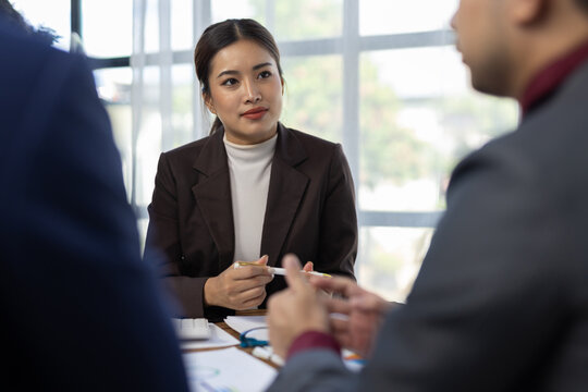 Business professionals discussing work during a corporate meeting. Business professionals collaborating and having a discussion in a corporate meeting, teamwork and strategic planning.