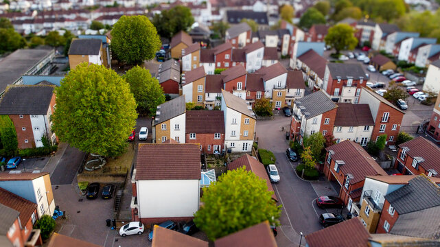 Aerial view of a cozy residential neighborhood with trees and cars.