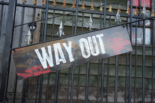 Distressed Way Out sign on black iron railings at Goose Fair
