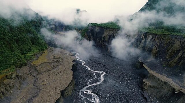 Fog Drifting Through Steep River Canyon in Tropical Mountains