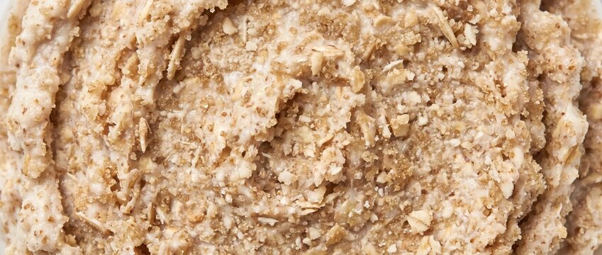 Oat scrub texture background. Close up of cosmetic body exfoliant paste with ground oats and sugar granules