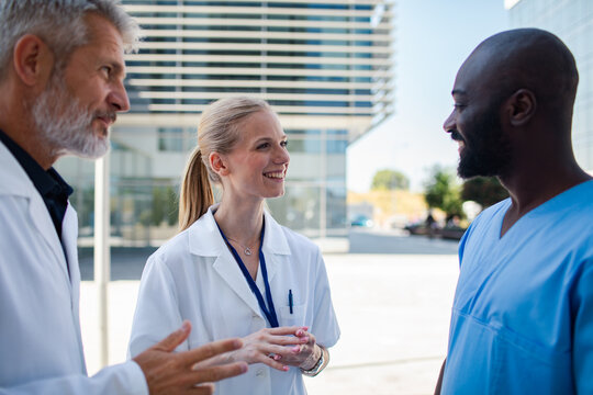 Smiling medical team talking outside a hospital