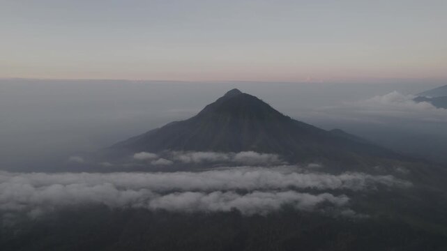 Aerial View of Majestic Mountain Peak Rising Above a Sea of Clouds before sunrise at Ranti Mountain East Java, Banyuwangi