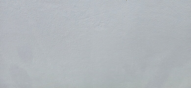 A slightly textured plastered or light-grey painted wall surface, featuring the natural roughness characteristic of plasterwork. Skim coat finish. Coated with primer and topcoat. 
