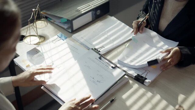 Lawyers Reviewing Legal Documents and Discussing Case in Law Office