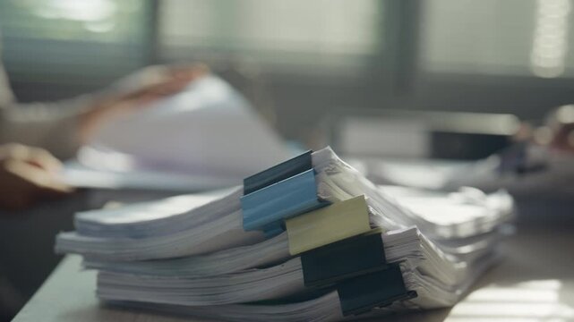 Stack of Office Documents Representing Heavy Workload and Paperwork Overload