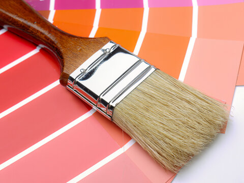 Paintbrush on Pink and Orange Color Swatches for Home Interior Painting and Design Palette Selection