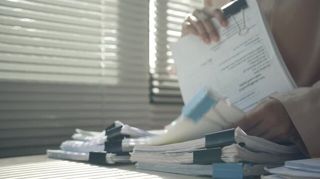 Businesswoman Organizing and Reviewing Documents at Modern Office Desk