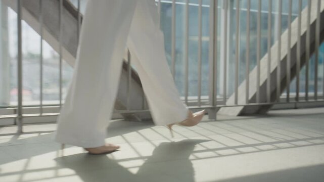 Businesswoman Walking Barefoot in Sunlit Modern Office Building