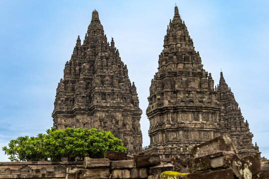 Prambanan Temple in Central Java, Indonesia. A vast 9th-century Hindu temple complex with intricate stone spires, sculptures, and ancient ruins under a cloudy sky.