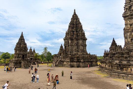 Prambanan Temple in Central Java, Indonesia. A vast 9th-century Hindu temple complex with intricate stone spires, sculptures, and ancient ruins under a cloudy sky.