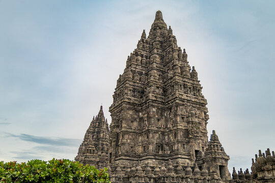 Prambanan Temple in Central Java, Indonesia. A vast 9th-century Hindu temple complex with intricate stone spires, sculptures, and ancient ruins under a cloudy sky.