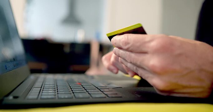 Online Shopping Experience: A person's hands hold a credit card, poised to make a purchase while looking at a laptop screen. This captures the essence of digital commerce and convenience.