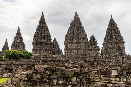 Prambanan Temple in Central Java, Indonesia. A vast 9th-century Hindu temple complex with intricate stone spires, sculptures, and ancient ruins under a cloudy sky.