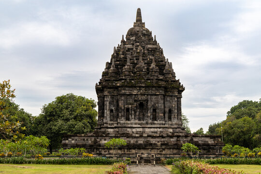 Prambanan Temple in Central Java, Indonesia. A vast 9th-century Hindu temple complex with intricate stone spires, sculptures, and ancient ruins under a cloudy sky.