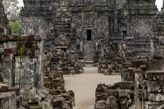 Prambanan Temple in Central Java, Indonesia. A vast 9th-century Hindu temple complex with intricate stone spires, sculptures, and ancient ruins under a cloudy sky.