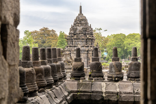 Prambanan Temple in Central Java, Indonesia. A vast 9th-century Hindu temple complex with intricate stone spires, sculptures, and ancient ruins under a cloudy sky.