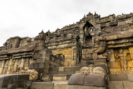 Ancient stone stupas of Borobudur, a UNESCO World Heritage Buddhist monument in Central Java, Indonesia, under an overcast sky.