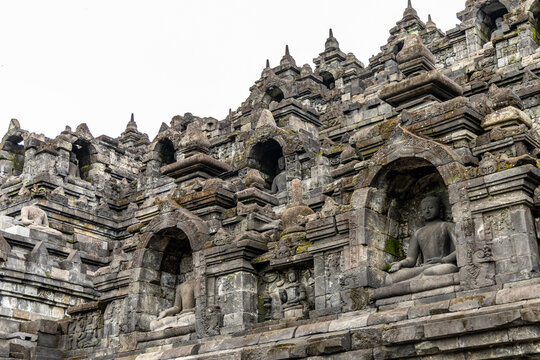 Ancient stone stupas of Borobudur, a UNESCO World Heritage Buddhist monument in Central Java, Indonesia, under an overcast sky.