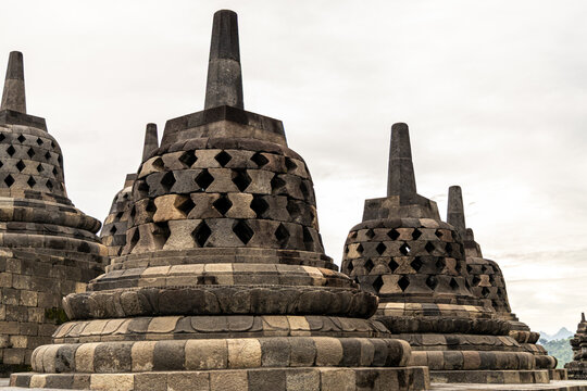 Ancient stone stupas of Borobudur, a UNESCO World Heritage Buddhist monument in Central Java, Indonesia, under an overcast sky.