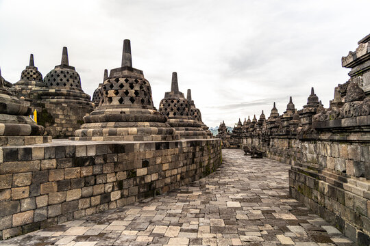 Ancient stone stupas of Borobudur, a UNESCO World Heritage Buddhist monument in Central Java, Indonesia, under an overcast sky.