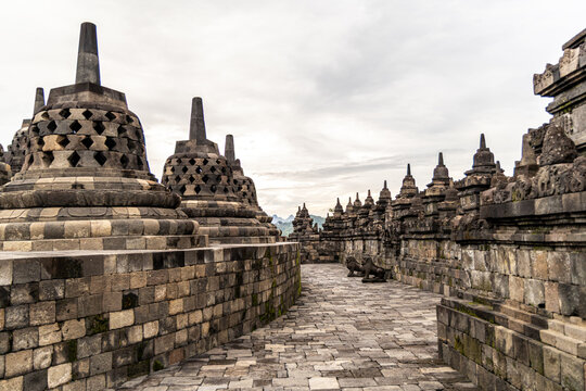 Ancient stone stupas of Borobudur, a UNESCO World Heritage Buddhist monument in Central Java, Indonesia, under an overcast sky.