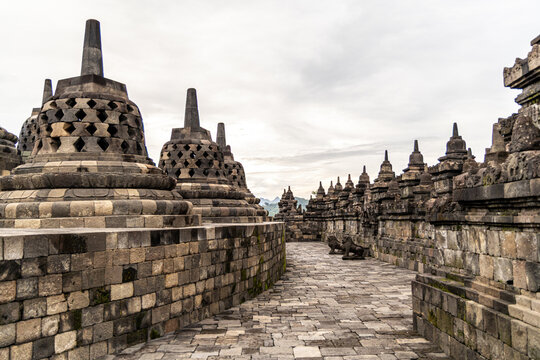 Ancient stone stupas of Borobudur, a UNESCO World Heritage Buddhist monument in Central Java, Indonesia, under an overcast sky.