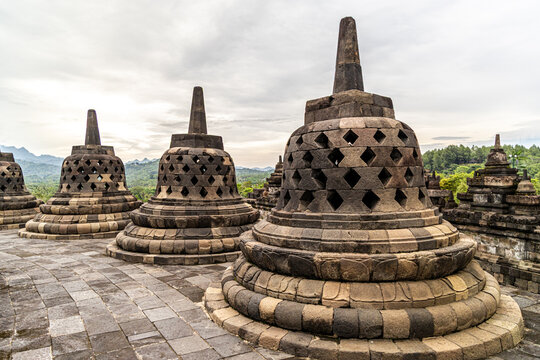 Ancient stone stupas of Borobudur, a UNESCO World Heritage Buddhist monument in Central Java, Indonesia, under an overcast sky.