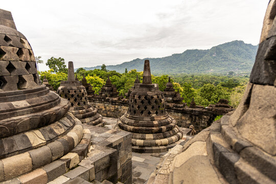 Ancient stone stupas of Borobudur, a UNESCO World Heritage Buddhist monument in Central Java, Indonesia, under an overcast sky.