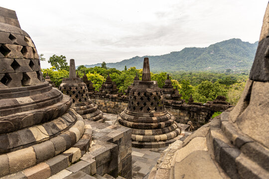 Ancient stone stupas of Borobudur, a UNESCO World Heritage Buddhist monument in Central Java, Indonesia, under an overcast sky.