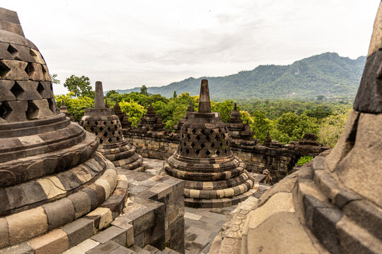 Ancient stone stupas of Borobudur, a UNESCO World Heritage Buddhist monument in Central Java, Indonesia, under an overcast sky.