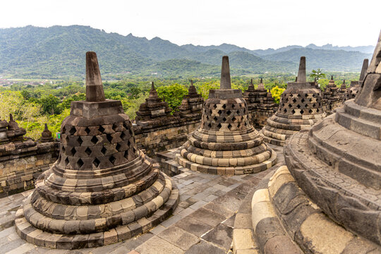 Ancient stone stupas of Borobudur, a UNESCO World Heritage Buddhist monument in Central Java, Indonesia, under an overcast sky.