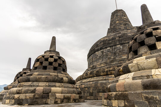 Ancient stone stupas of Borobudur, a UNESCO World Heritage Buddhist monument in Central Java, Indonesia, under an overcast sky.
