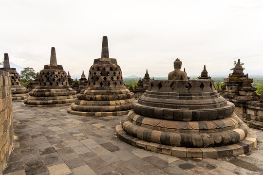 Ancient stone stupas of Borobudur, a UNESCO World Heritage Buddhist monument in Central Java, Indonesia, under an overcast sky.