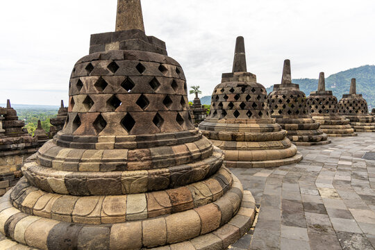 Ancient stone stupas of Borobudur, a UNESCO World Heritage Buddhist monument in Central Java, Indonesia, under an overcast sky.