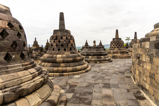 Ancient stone stupas of Borobudur, a UNESCO World Heritage Buddhist monument in Central Java, Indonesia, under an overcast sky.