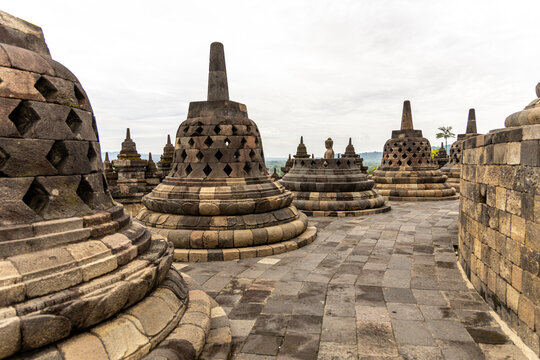 Ancient stone stupas of Borobudur, a UNESCO World Heritage Buddhist monument in Central Java, Indonesia, under an overcast sky.