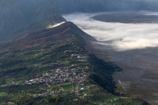 Mount Bromo volcano at sunrise, viewed from King Kong viewpoint in Bromo Tengger Semeru National Park, East Java, Indonesia. Active crater smoke, Mount Semeru cone, clouds, and vast ash plain.