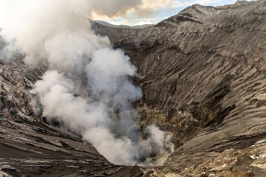 Active Mount Bromo volcano crater with sulfur smoke and volcanic sand sea, Tengger Semeru National Park, East Java, Indonesia.