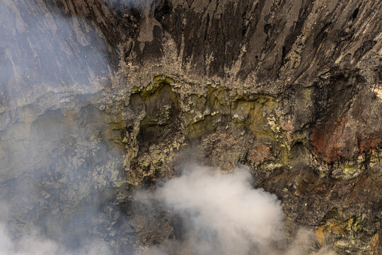 Active Mount Bromo volcano crater with sulfur smoke and volcanic sand sea, Tengger Semeru National Park, East Java, Indonesia.