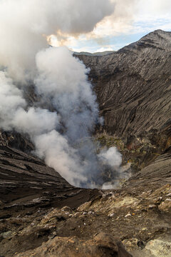 Active Mount Bromo volcano crater with sulfur smoke and volcanic sand sea, Tengger Semeru National Park, East Java, Indonesia.
