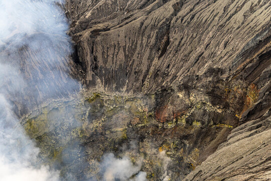 Active Mount Bromo volcano crater with sulfur smoke and volcanic sand sea, Tengger Semeru National Park, East Java, Indonesia.