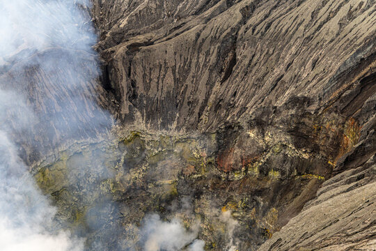 Active Mount Bromo volcano crater with sulfur smoke and volcanic sand sea, Tengger Semeru National Park, East Java, Indonesia.