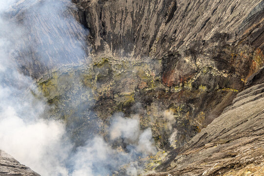 Active Mount Bromo volcano crater with sulfur smoke and volcanic sand sea, Tengger Semeru National Park, East Java, Indonesia.