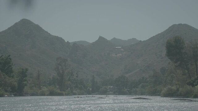 Hazy layered mountains over a forested valley and riverbed