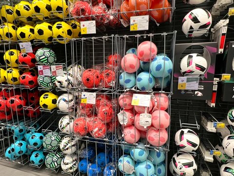 Soccer balls displayed on retail store shelf for sports equipment shopping.
