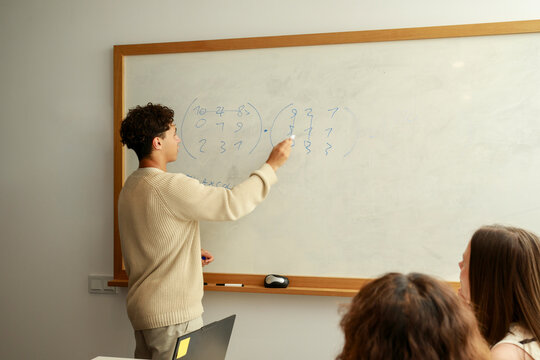 Teacher Explains Math Concepts to Students in a Classroom Setting